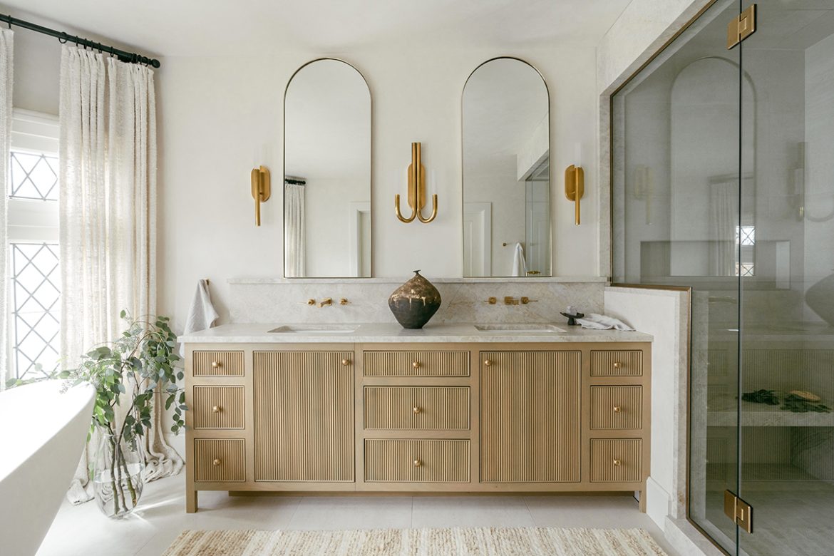 Bathroom Remodeling 62 | The Home X Modern double vanity bathroom remodel with vertical reeded cabinets, arched mirrors, and brass fixtures by The Home X.