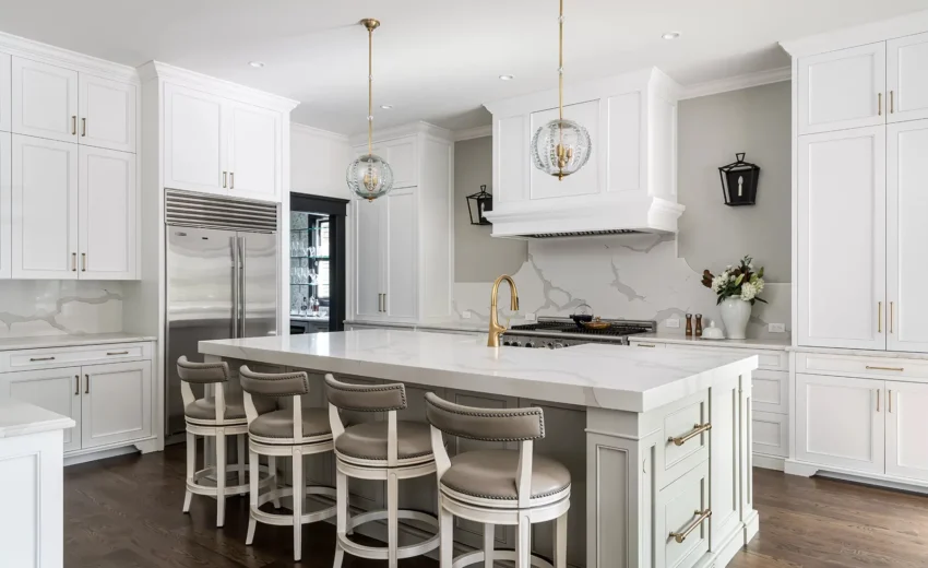 Elegant white kitchen with marble backsplash, large island, and pendant lighting.
