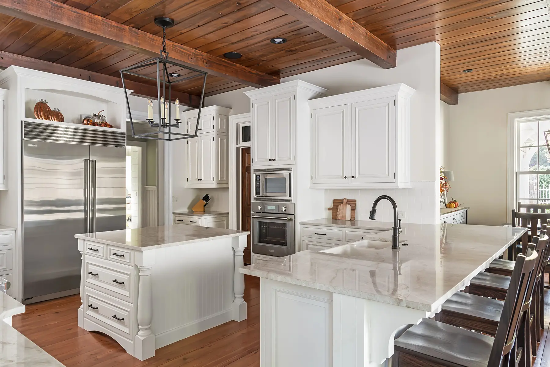 Woodhill Rd, Newtown, PA 18940 1 | The Home X Modern rustic kitchen with vaulted wood ceiling, waterfall island, and sleek white cabinetry in Newtown, PA remodel.