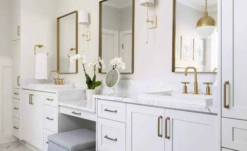 Refined bathroom vanity setup with white shaker cabinets, dual undermount sinks, quartz countertops, and brass hardware.