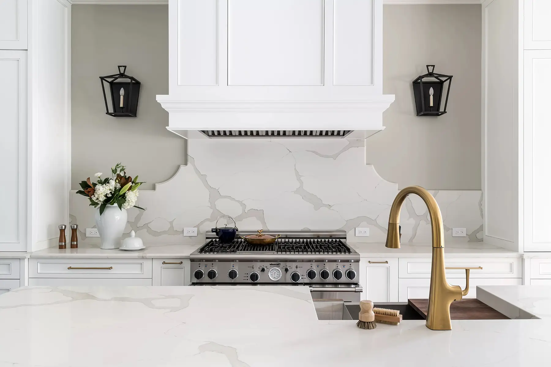 Moore St, Princeton, NJ 08540 3 | The Home X Elegant kitchen island with brass gooseneck faucet, white quartz counters, and sleek black sconces.