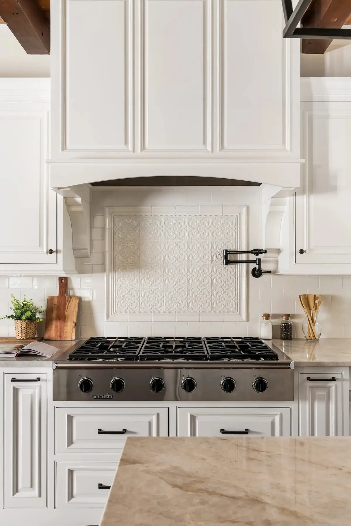 Woodhill Rd, Newtown, PA 18940 3 | The Home X Close-up of a kitchen range with white cabinetry, custom hood, and warm wood accents in Newtown, PA.