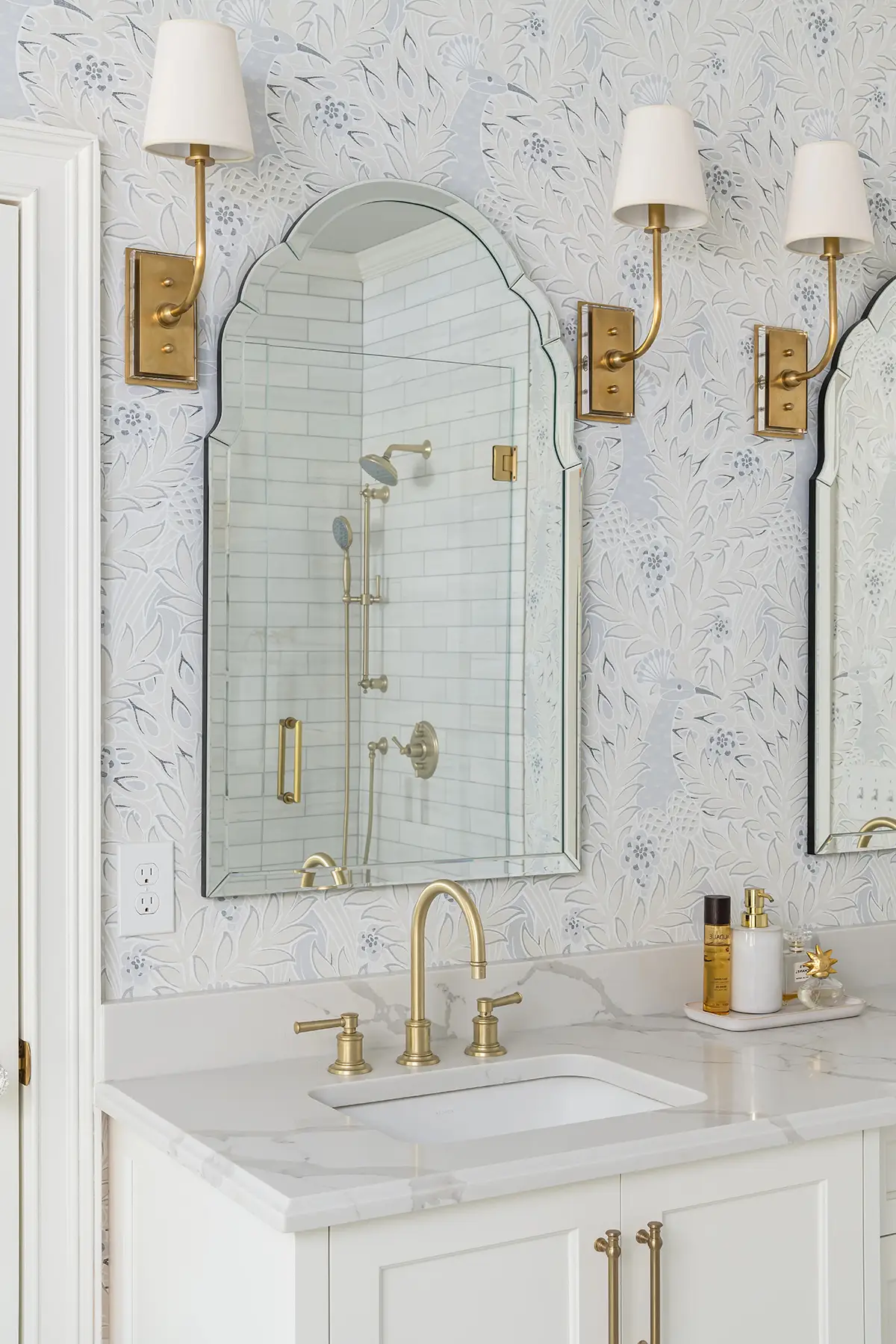 Great Rd, Princeton, NJ 08540 4 | The Home X Luxury bathroom vanity with marble backsplash, arched mirror, and brass sconces in Princeton, NJ
