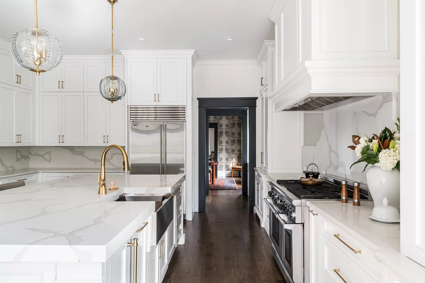 Moore St, Princeton, NJ 08540 6 | The Home X Transitional galley kitchen with white cabinets, globe pendant lighting, and dark wood flooring.