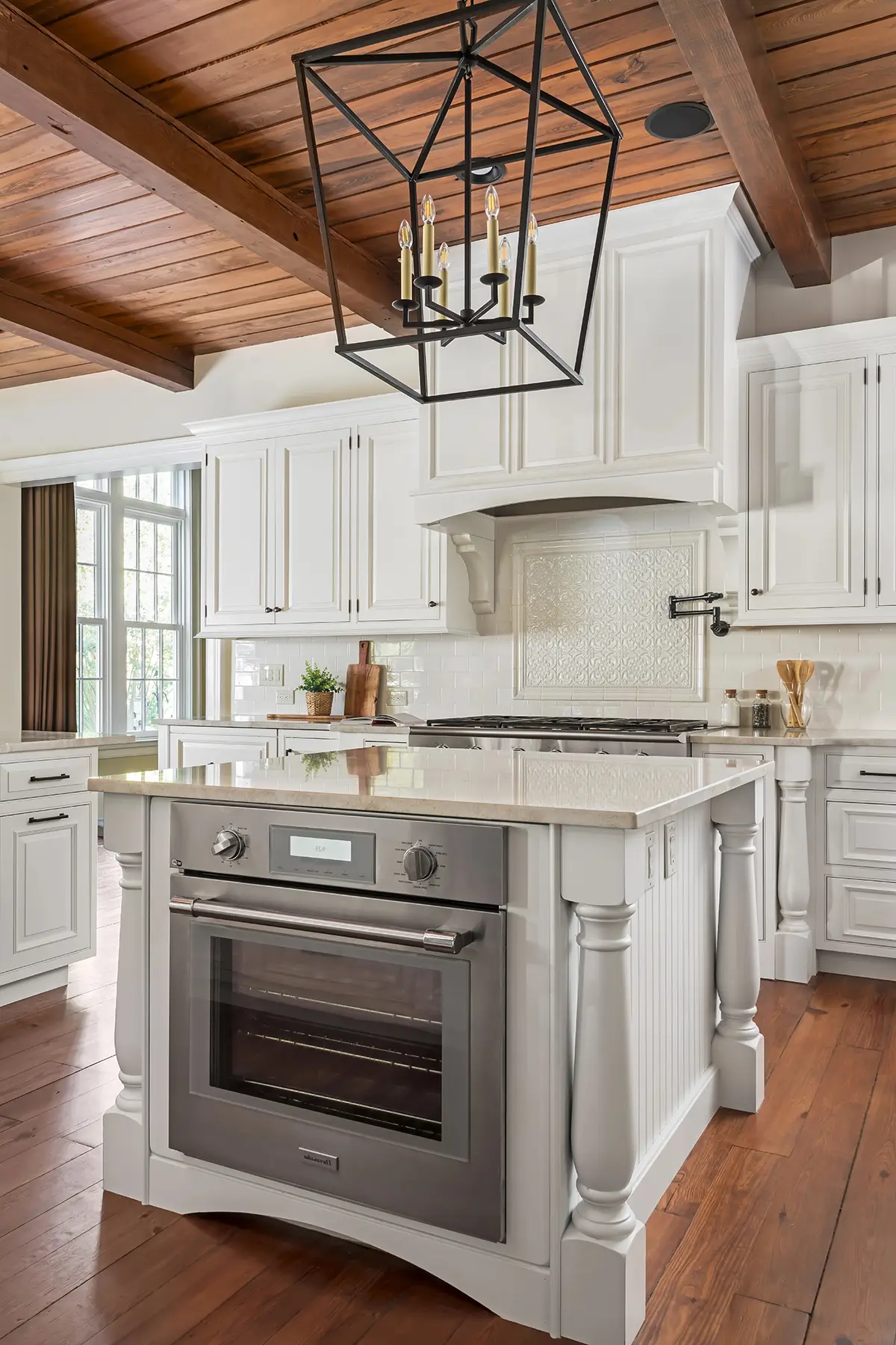 Woodhill Rd, Newtown, PA 18940 7 | The Home X Bright white kitchen with wood beam ceiling, farmhouse range hood, and modern chandelier.