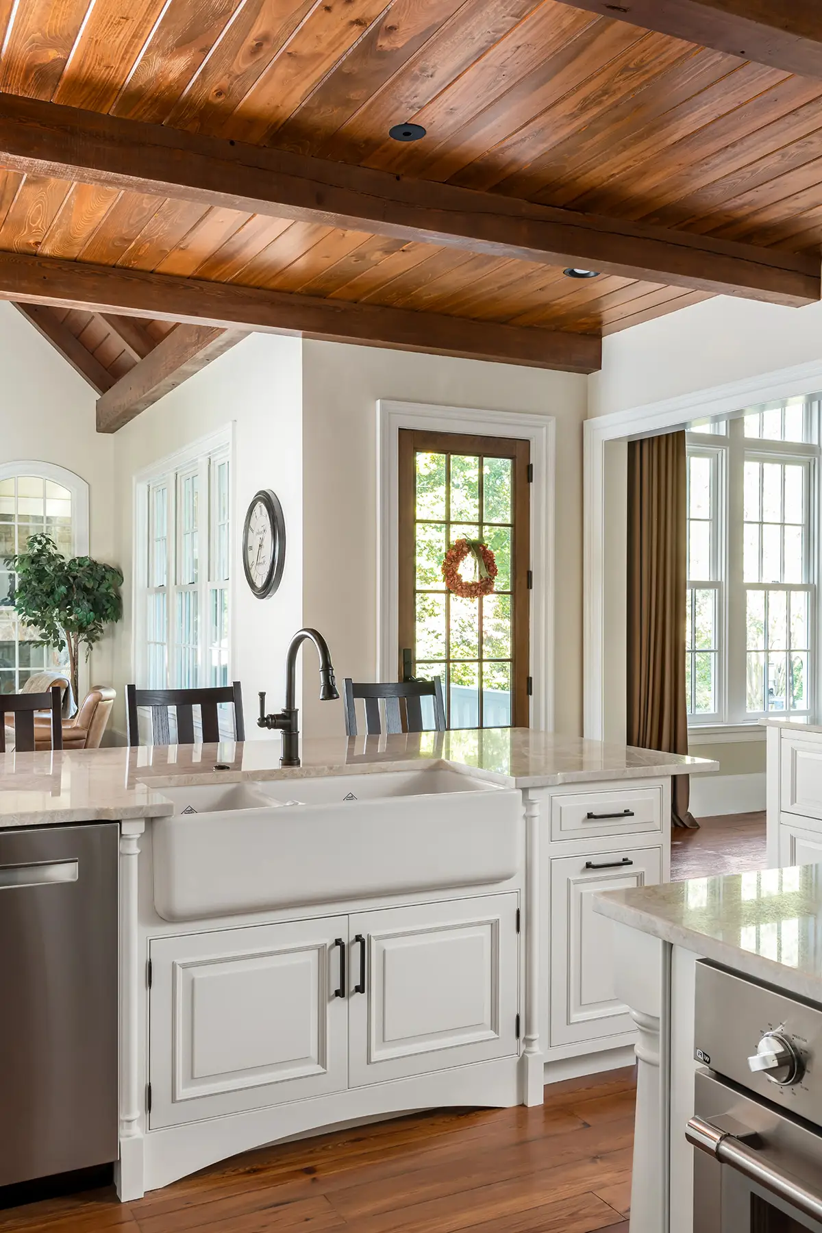 Woodhill Rd, Newtown, PA 18940 8 | The Home X White kitchen with wood ceiling, large island, and black lantern pendant lighting.