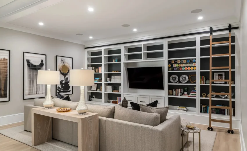 Elegant basement living room with custom built-ins, recessed lighting, and neutral furniture in Newtown PA remodel