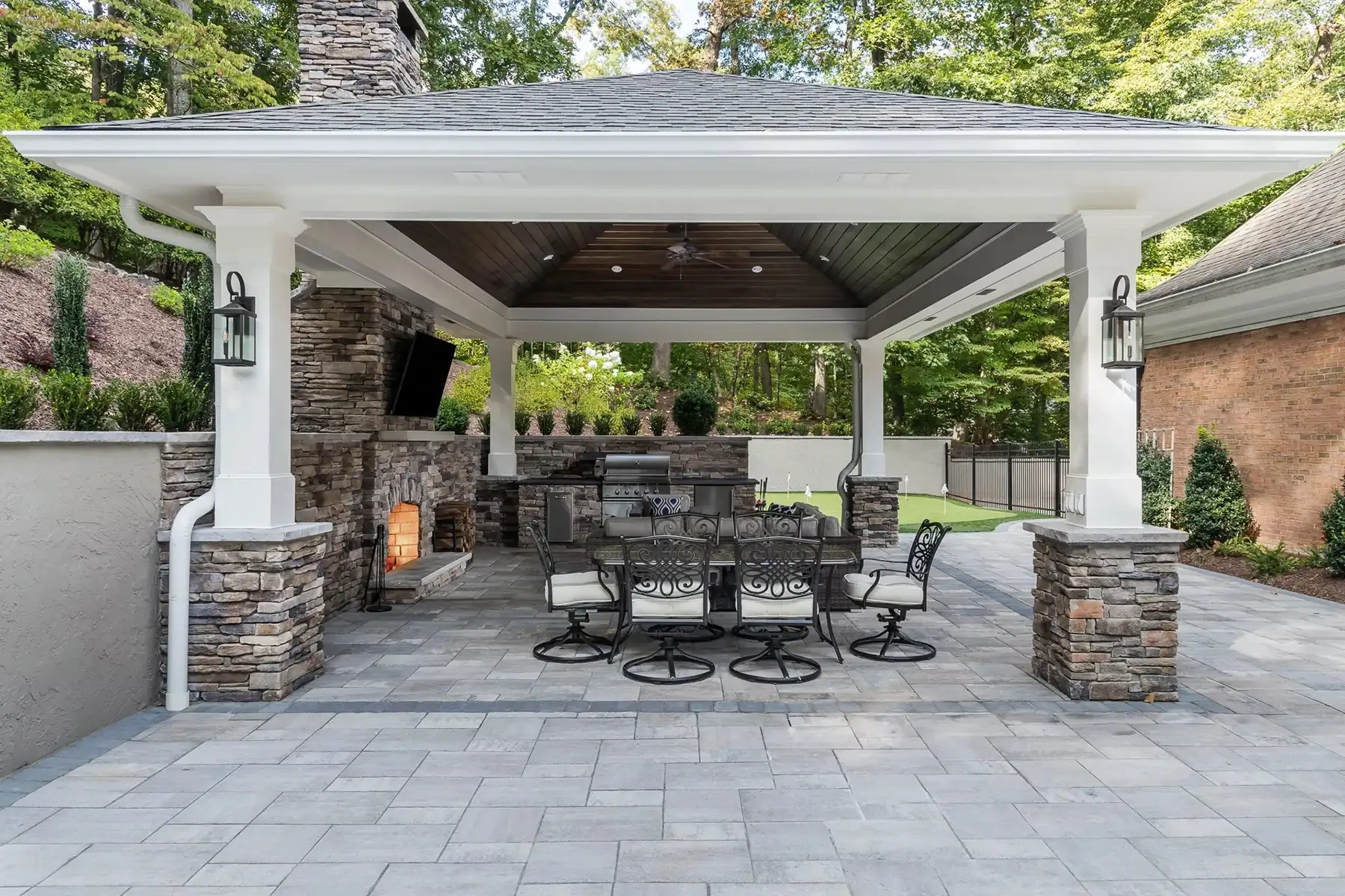 Sergeantsville Rd, Delaware Twp., 08559 2 | The Home X Covered outdoor dining area with wood ceiling, stone columns, and modern table setting.