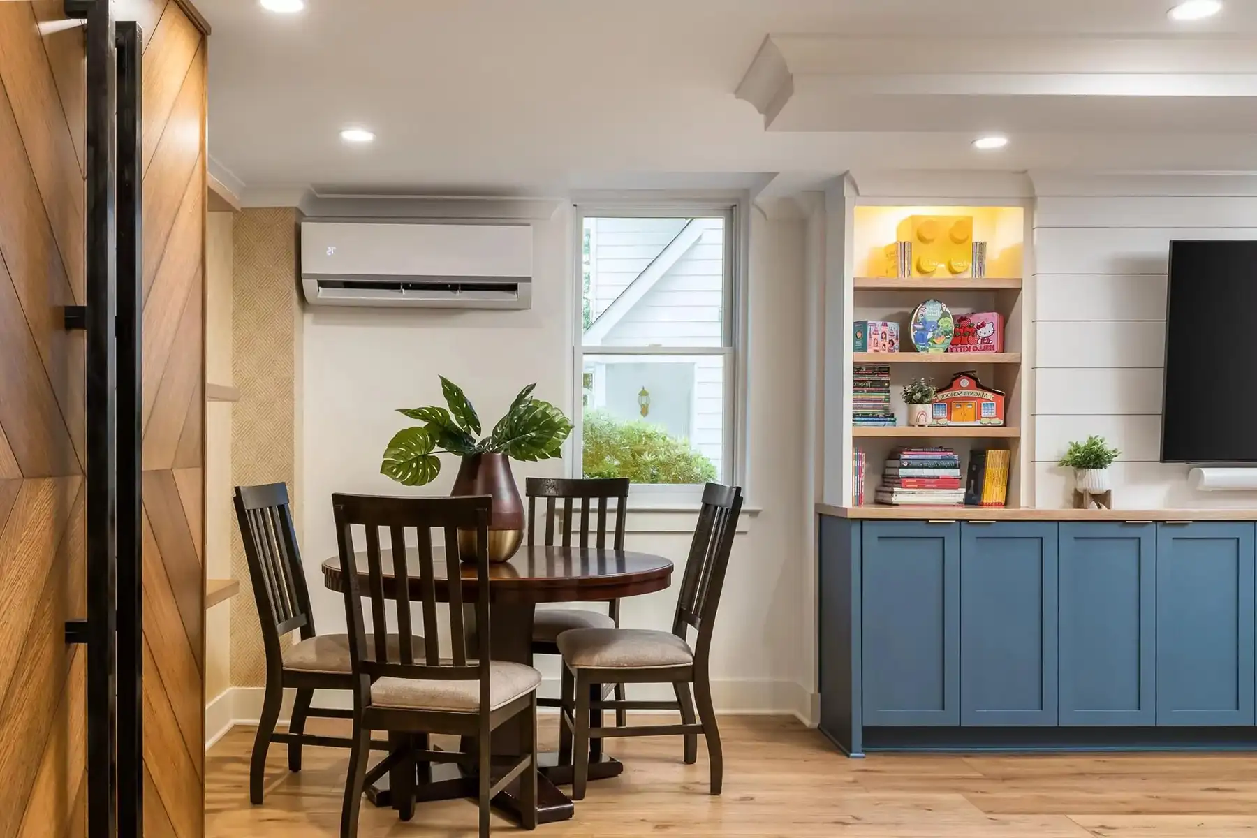 Federal City Rd, Pennington, NJ 08534 4 | The Home X Open-concept basement with dining nook, blue custom cabinetry, wall-mounted TV, and wood shelving.