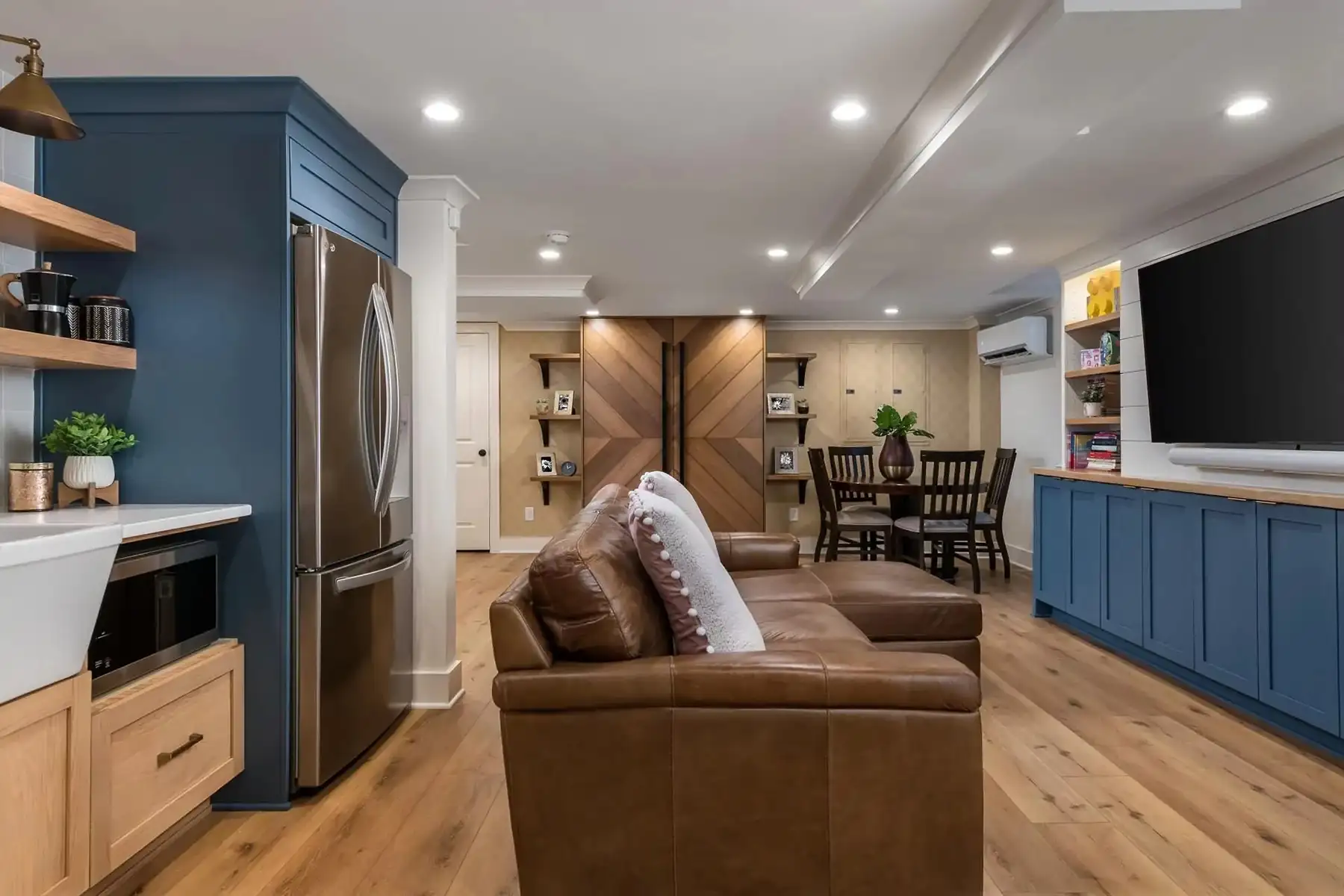 Federal City Rd, Pennington, NJ 08534 7 | The Home X Wide-angle view of finished basement with built-in media wall, seating area, and natural wood flooring.