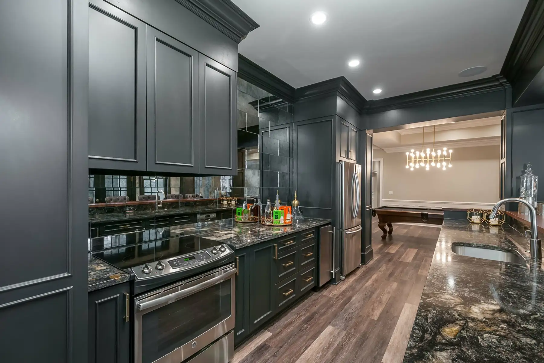 Lower Mountain Rd, New Hope, PA 18938 5 | The Home X Dark modern basement kitchen with matte black cabinets, wood flooring, and recessed lighting in New Hope, PA.