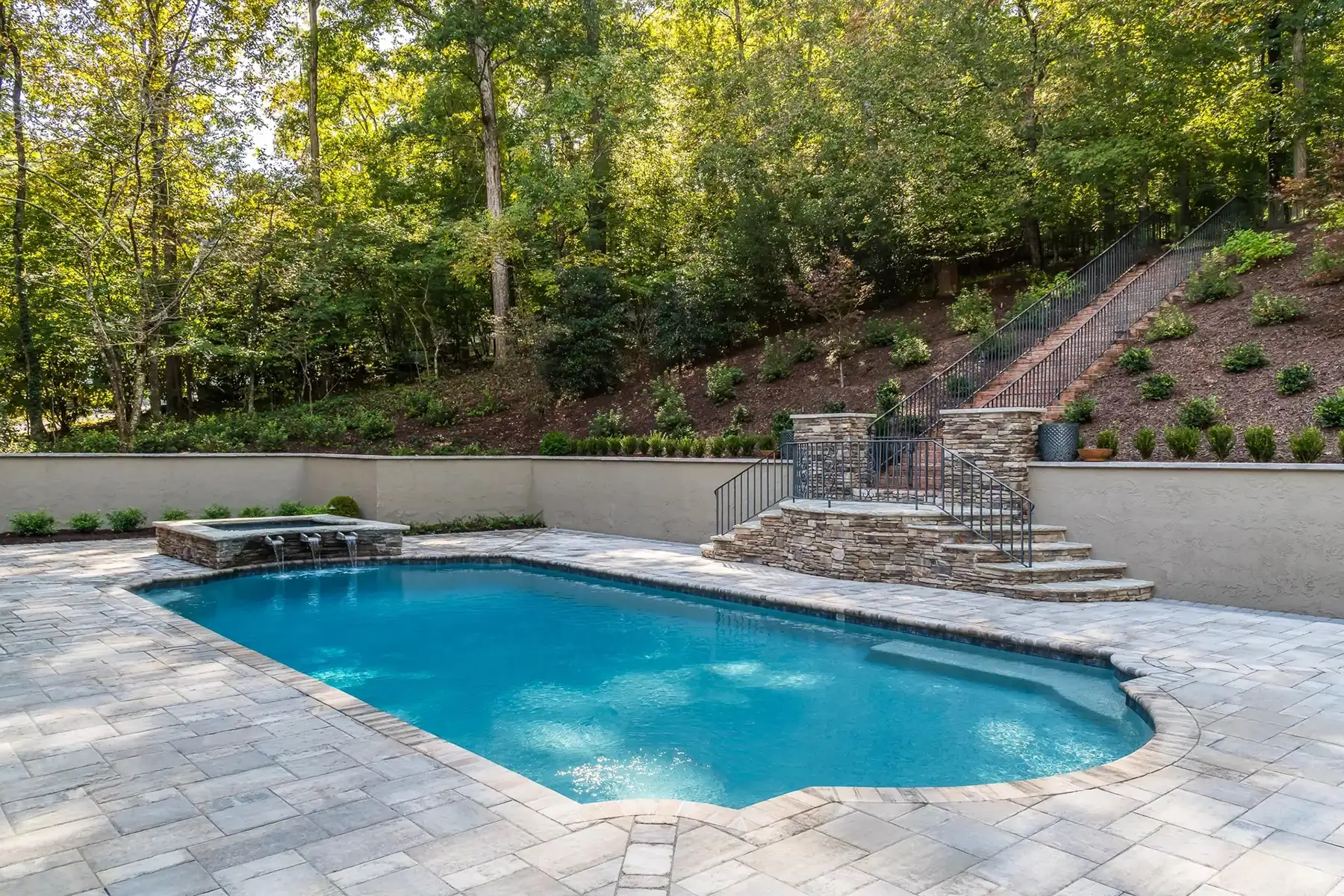 Sergeantsville Rd, Delaware Twp., 08559 5 | The Home X Backyard pool surrounded by stone retaining wall, stairs, and forest backdrop.