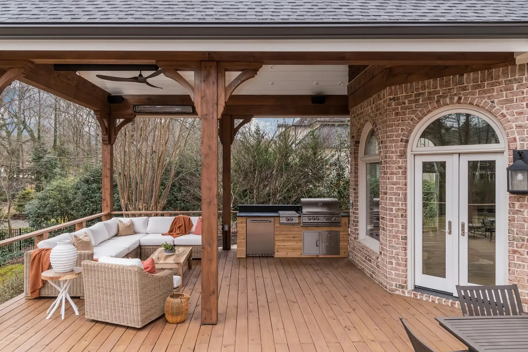 Aquetong Rd, New Hope, Pa 18938 6 | The Home X Covered deck with exposed wood beams, paver flooring, arched French doors, and cozy outdoor seating area.