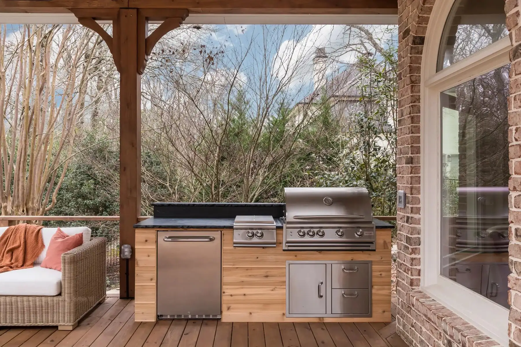 Aquetong Rd, New Hope, Pa 18938 7 | The Home X Outdoor lounge with cedar beam ceiling, stacked stone fireplace, flat-screen TV, and dual seating zones under a covered roof.