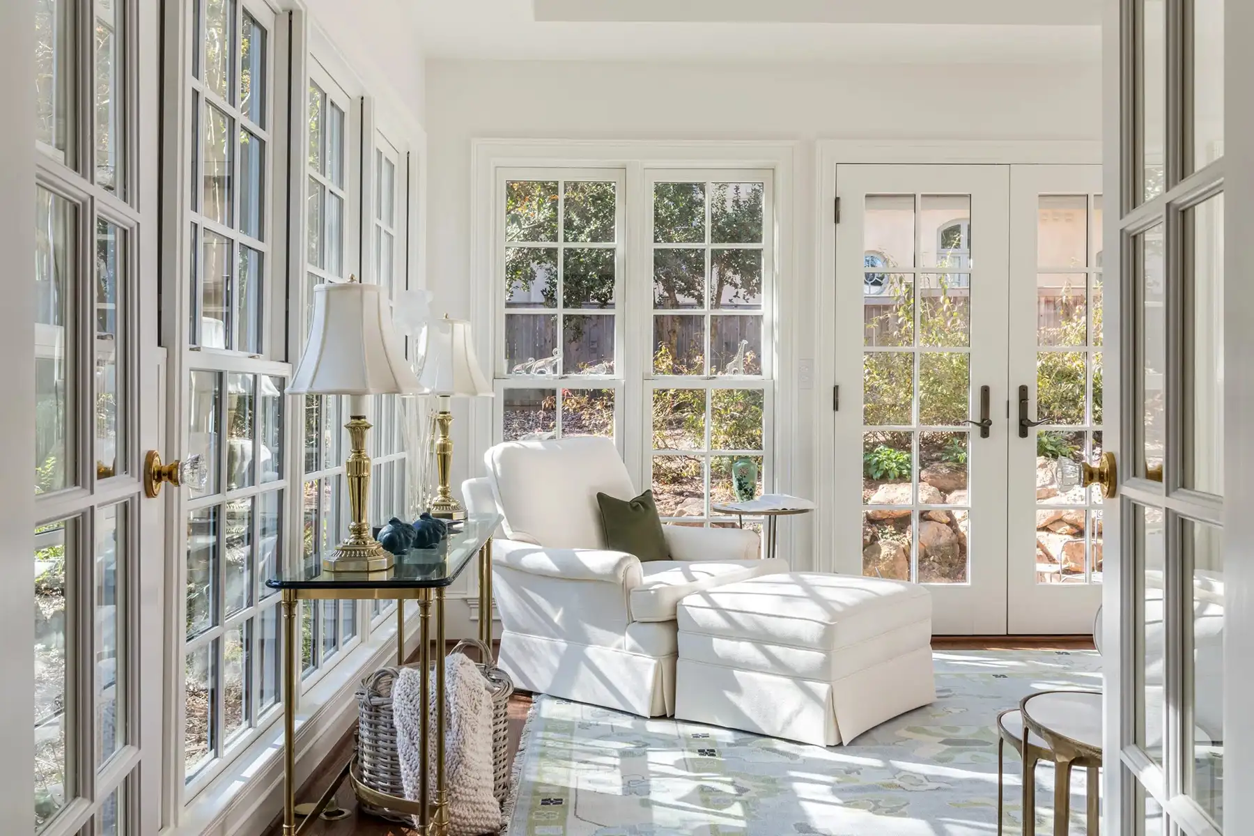 Woodside Rd, Yardley, PA 19067 6 | The Home X Sunroom with wall-to-wall windows, white furniture, and a round table centered in natural light.