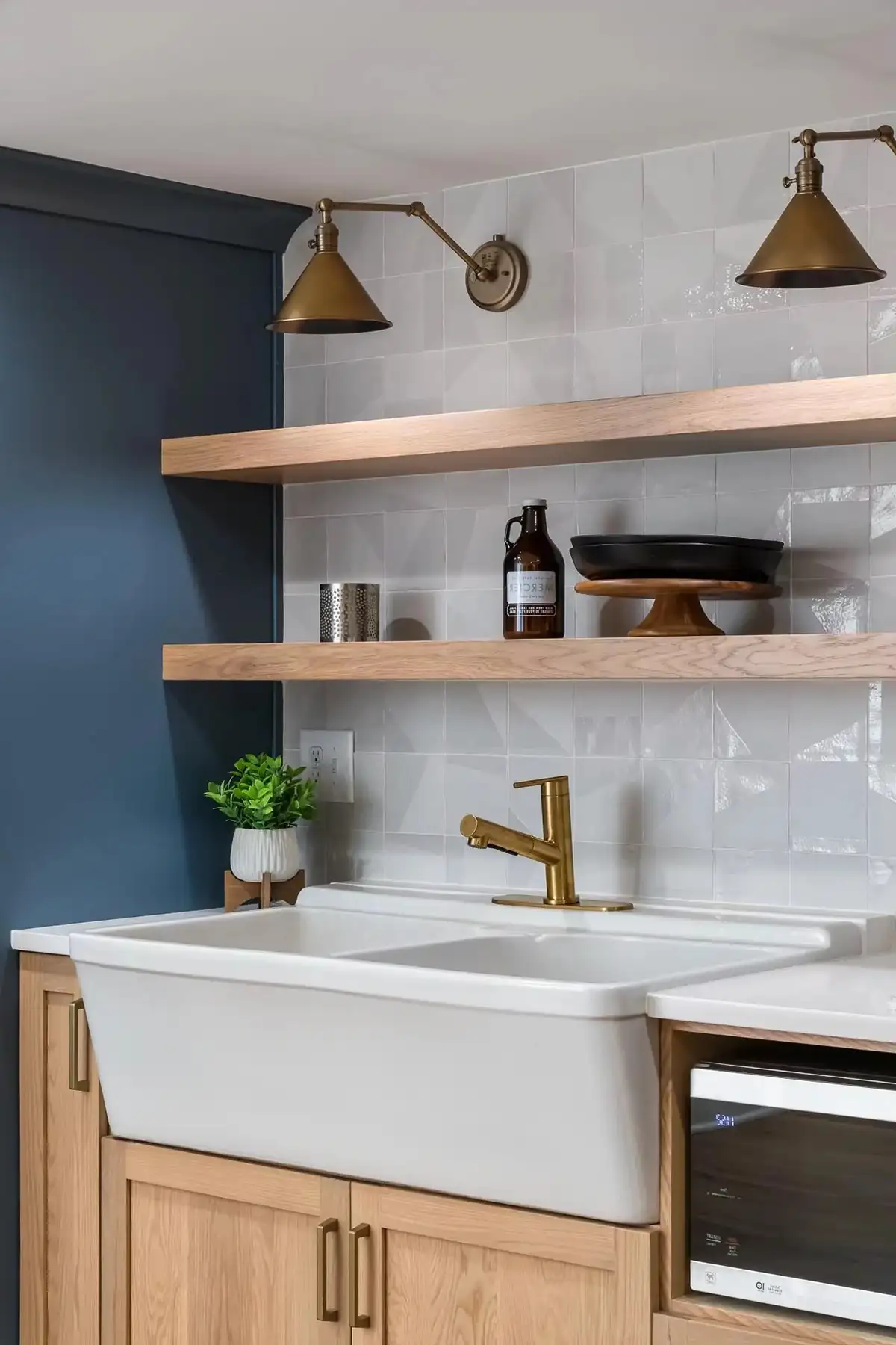 Federal City Rd, Pennington, NJ 08534 10 | The Home X Modern kitchen featuring blue cabinetry, open wooden shelves, white marble countertops, and brass pendant lighting.