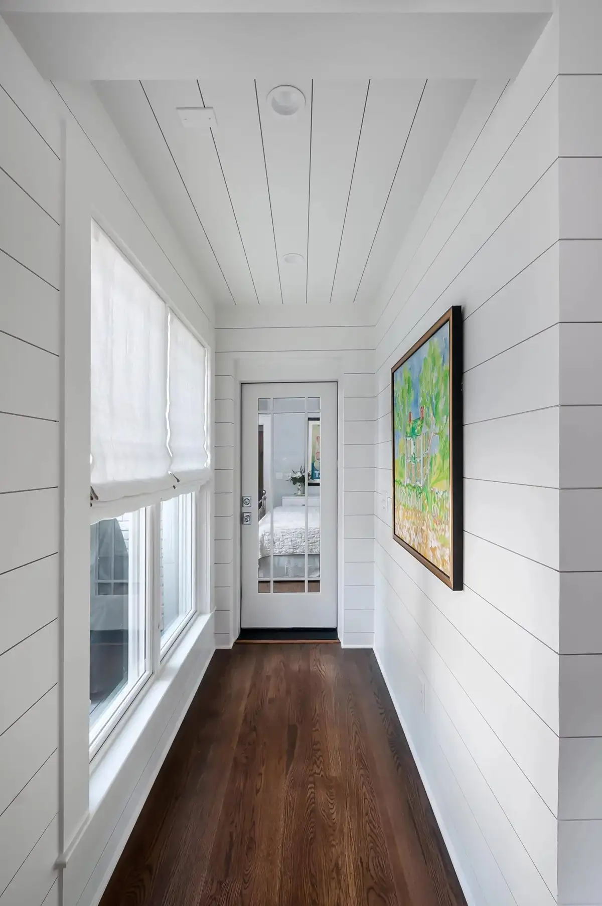Washington Crossing Pennington Rd, Pennington, NJ 08534 8 | The Home X Bright enclosed hallway with shiplap walls, picture windows, and dark wood flooring.