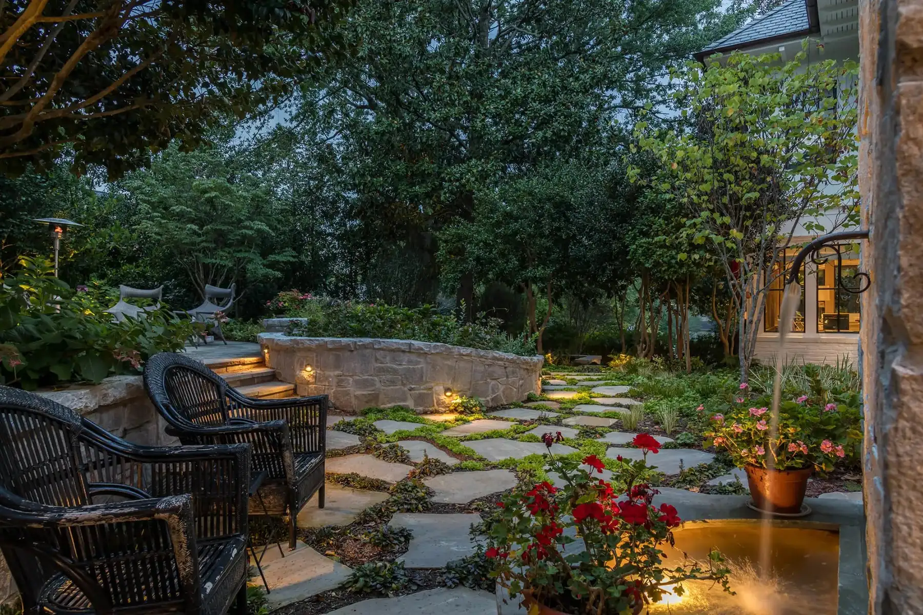 Pidcock Creek Rd, New Hope, PA 18938 10 | The Home X Evening view of a garden patio with glowing landscape lights and lush greenery in New Hope, PA.