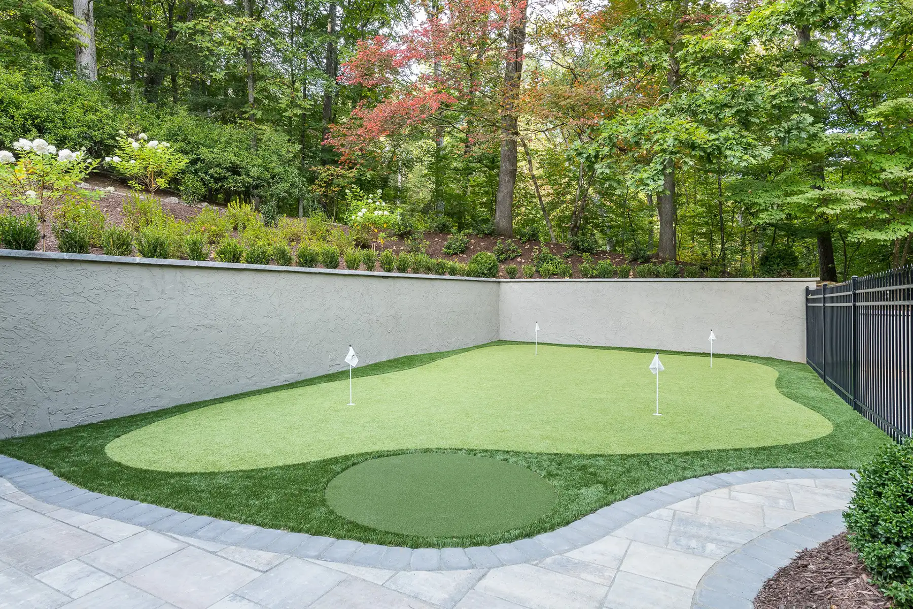 Sergeantsville Rd, Delaware Twp., 08559 15 | The Home X Private backyard putting green surrounded by manicured landscaping and retaining walls in Delaware Township.