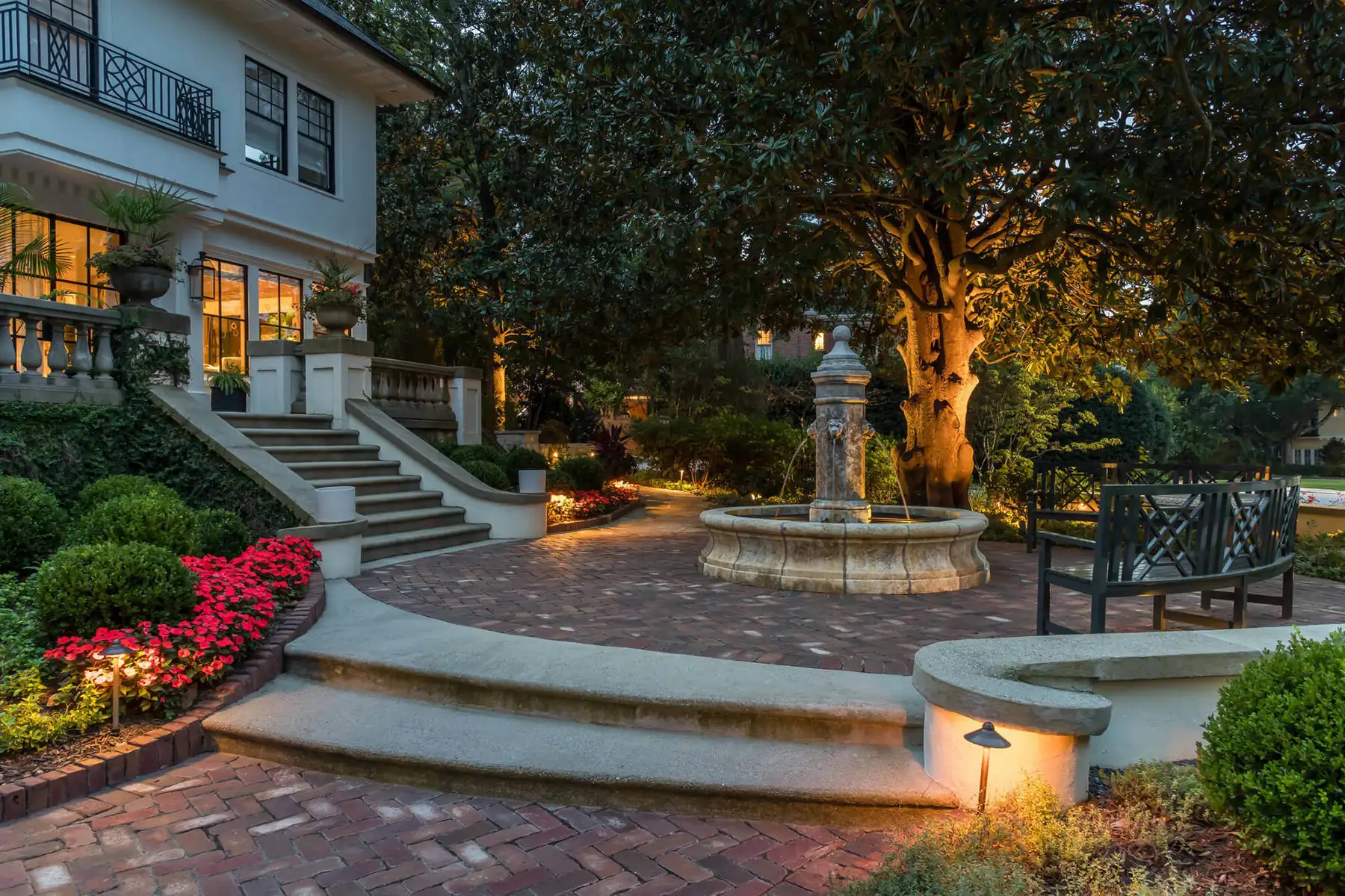 Pidcock Creek Rd, New Hope, PA 18938 16 | The Home X Brick garden steps and fountain illuminated at dusk with landscape lighting and surrounding trees.