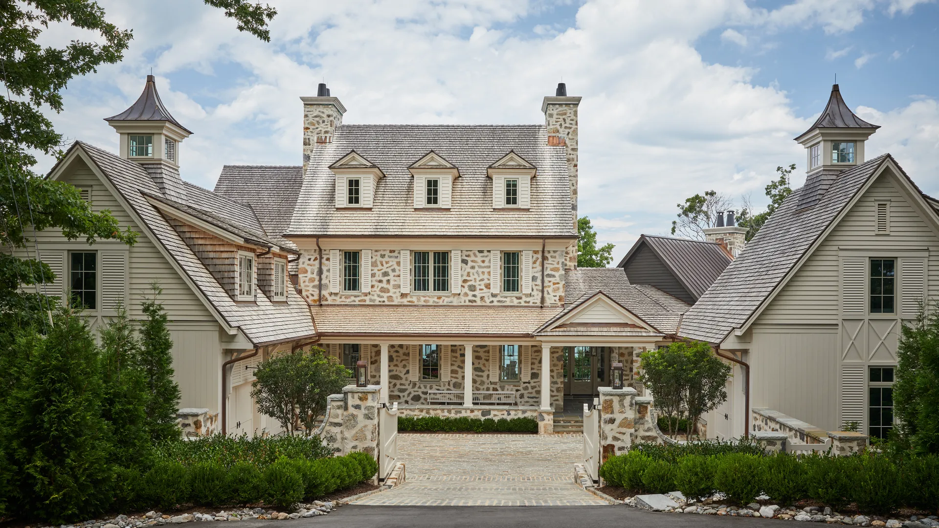 Elegant full-home remodel featuring symmetrical gables, standing seam metal roof, and custom exterior finishes by The Home X.