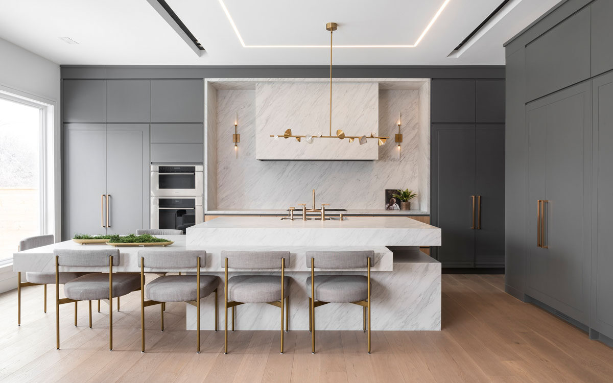 Minimalist luxury kitchen remodel with waterfall island, brass fixtures, and flat-panel cabinetry by The Home X.