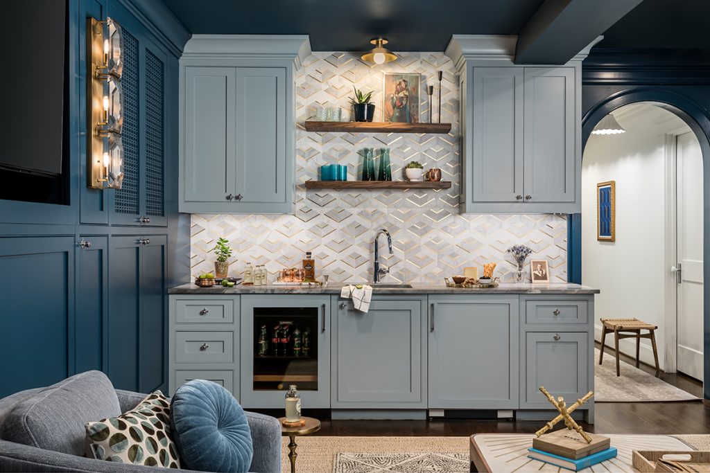 Moody luxury basement remodel with navy cabinetry, marble backsplash, and open shelving by The Home X.