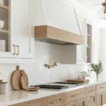 Light oak and white kitchen with brass accents, quartz countertops, and herringbone backsplash in modern farmhouse style