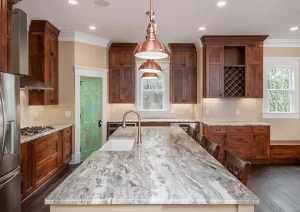 Kitchen island with granite countertop, wood cabinetry, and copper pendant lights in Lambertville, NJ