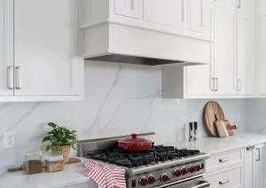 Luxury kitchen remodel in Princeton, NJ featuring a 36" gas range, custom hood, and white shaker cabinets
