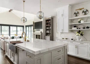 Bright transitional kitchen with a large island, barstools, and glass pendant lighting.