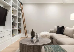 Modern finished basement with wall-mounted TV, soft gray sectional, and recessed lighting in Newtown PA remodel