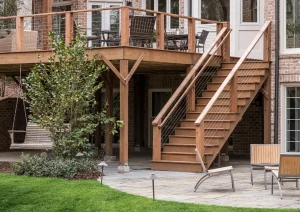 Timber staircase and stone columns on the rear exterior of a luxury New Hope home with upper and lower deck access.