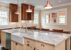 Traditional kitchen with farmhouse sink, granite island, and copper pendant lighting