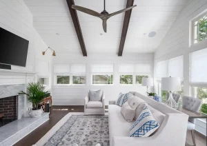 Expansive open-concept living space with vaulted ceiling, exposed wood beams, and modern furnishings.