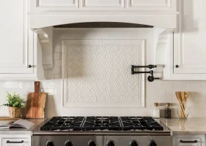 Close-up of a kitchen range with white cabinetry, custom hood, and warm wood accents in Newtown, PA.