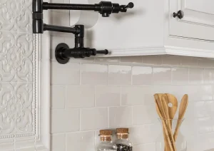Close-up of a white kitchen backsplash with matte black pot filler and geometric black-and-white countertop in Newtown, PA.