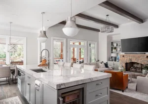 Bright kitchen with vaulted ceilings, white cabinetry, wood accents, and black fixtures in Princeton NJ