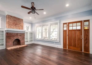 Living room with brick fireplace, wood floors, and glass French doors in Lambertville, NJ remodel