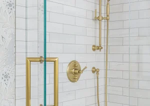Luxury shower with brass fixtures, vertical subway tile, and glass door in Princeton, NJ remodel