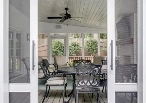 Screened-in porch entry with double doors and wood deck flooring at remodeled Great Rd home in Princeton, NJ.