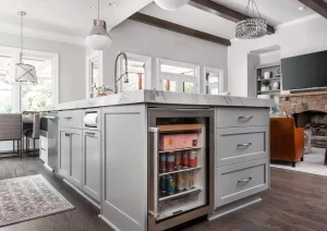 Modern gray kitchen island with built-in microwave, dark wood floors, and vaulted ceiling in Princeton NJ