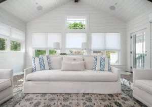 Elegant white living room with coffered ceiling, wood beams, and large windows.
