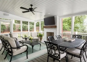 Four-season sunroom with vaulted ceiling, ceiling fan, and wicker seating at Great Rd home in Princeton, NJ.