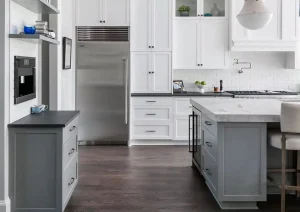 Full-length view of luxury white kitchen with waterfall island and dark wood flooring in Princeton NJ remodel