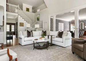 Bright luxury living room with layered neutrals, coffered ceiling, and elegant built-ins.
