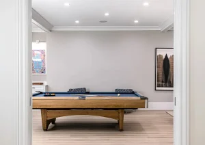 Modern basement hallway with light oak floors and custom wood bench in Newtown PA home remodel