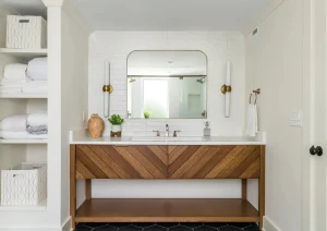 Elegant bathroom vanity with double sinks, wooden cabinetry, and a large mirror under soft lighting.