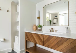 Modern bathroom with a wooden vanity, large mirror, white walls, and minimalist fixtures.