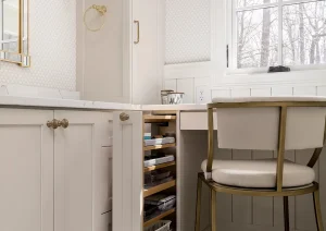 Bathroom makeup vanity with pull-out drawer seating and marble-look floors in New Hope, PA remodel